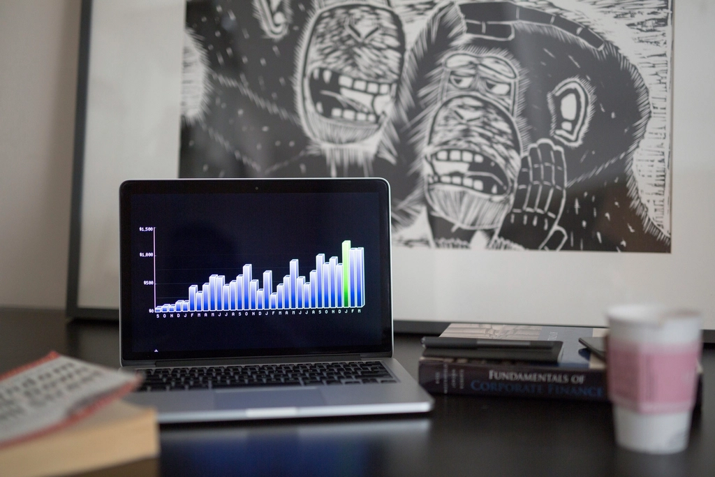 Laptop mostrando un gráfico de barras con tendencia de crecimiento financiero