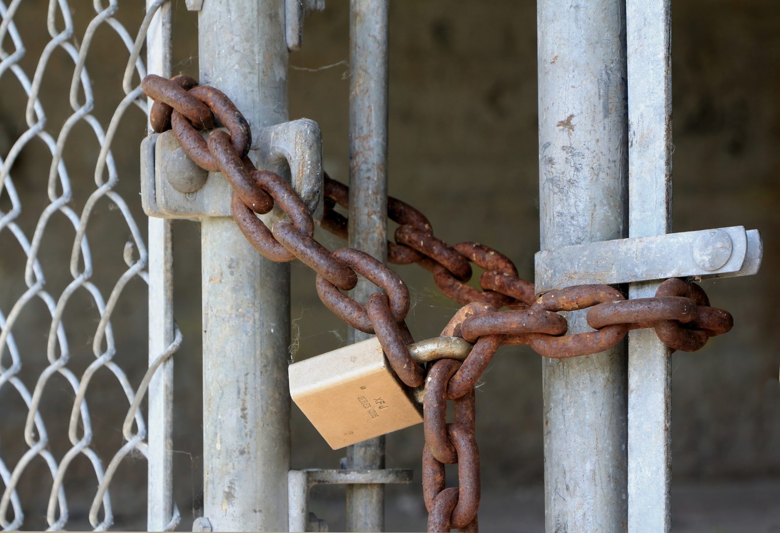 Candado y cadena oxidados asegurando una reja metalica, simbolo de seguridad y proteccion de datos